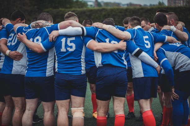 Group of people, young and strong rugby team on the field, celebrating their victory.